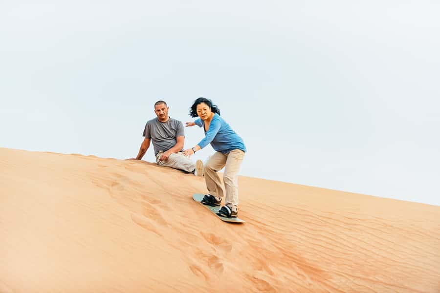 Doha: Desert Safari Dune Bashing, Sandboarding, & Camel Ride - Sandboarding for a free extra thrill